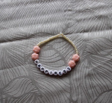 Armbnd med lyserd blomster og hvide sm perler